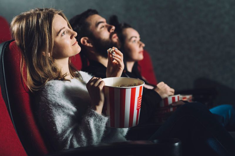 people-with-popcorn-enjoying-movie_23-2147803794