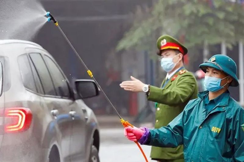 Petugas-anti-virus-corona-Vietnam-menyempotkan-cairan-kimia-ke-kendaraan-foto-si