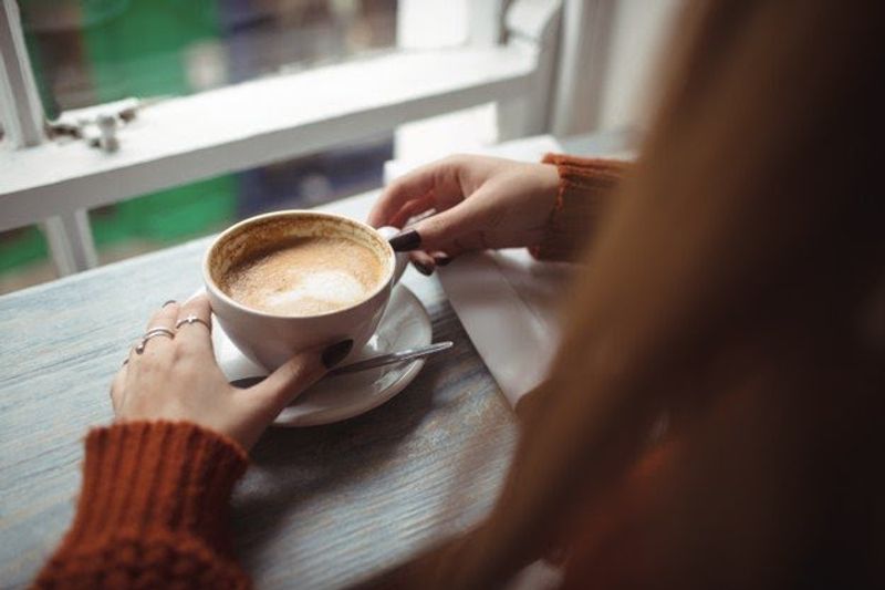 woman-holding-coffee-cup_107420-96313 width-800