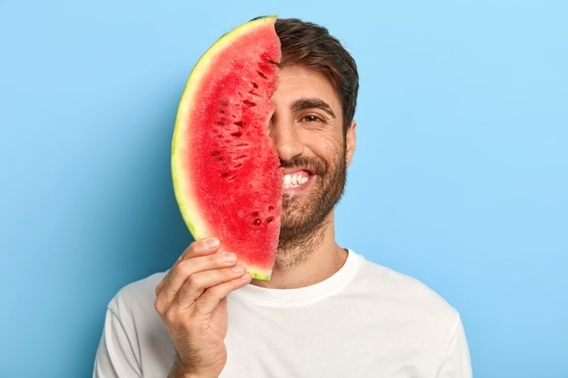 cheerful-man-summer-day-holding-slice-watermelon_273609-31610