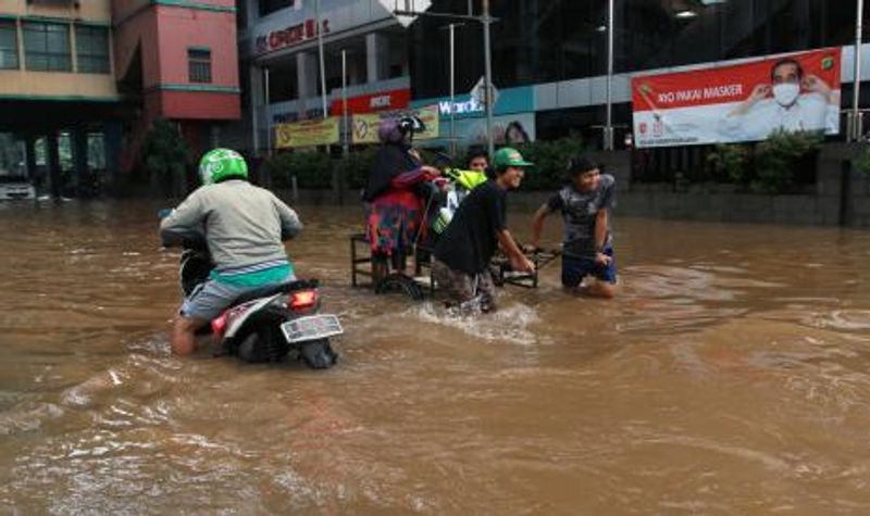 warga-memanfaatkan-ojek-gerobak-untuk-melewati-banjir-di-kawasan_210220140800-93