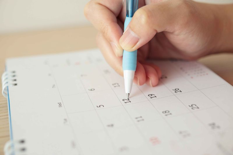 hand-with-pen-writing-calendar-date_11zon
