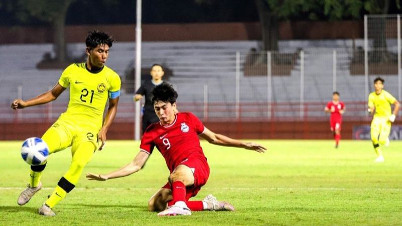 Kapten Timnas Malaysia U-19 Ariff Safwan membawa bola dihalangi pemain Singapura Kian Jared Ghadessy