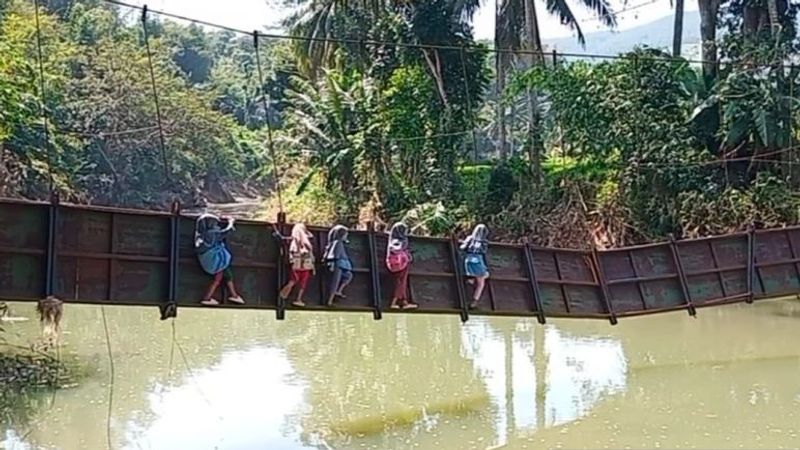 pelajar bergelantungan para rangka jembatan yang sudah rusak