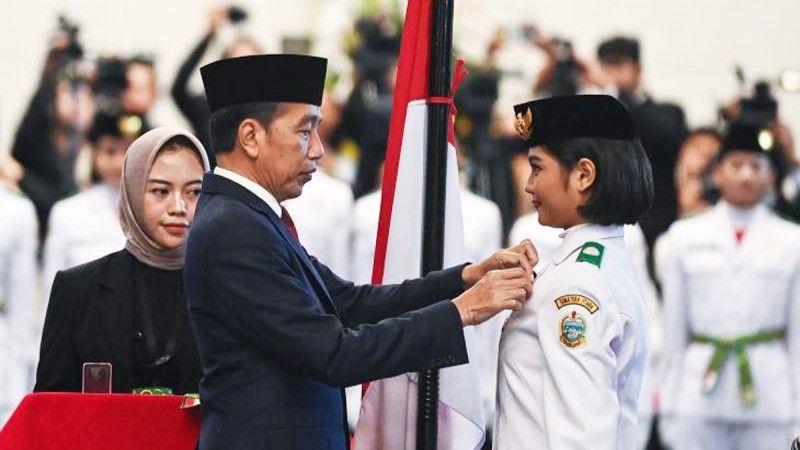 Presiden Joko Widodo (tengah) menyematkan lencana kepada anggota Paskibraka 2024