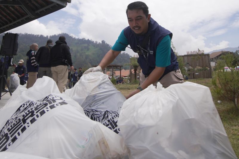 Seorang peserta aksi sedang membersihkan sampah di Gunung Prau