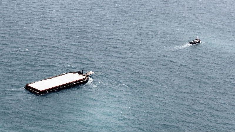 Sebuah kapal tunda menarik tongkang berisi pasir laut yang akan dibawa ke Singapura