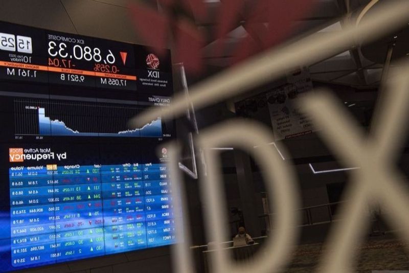 Karyawan berada di dekat layar pergerakan Indeks Harga Saham Gabungan (IHSG)