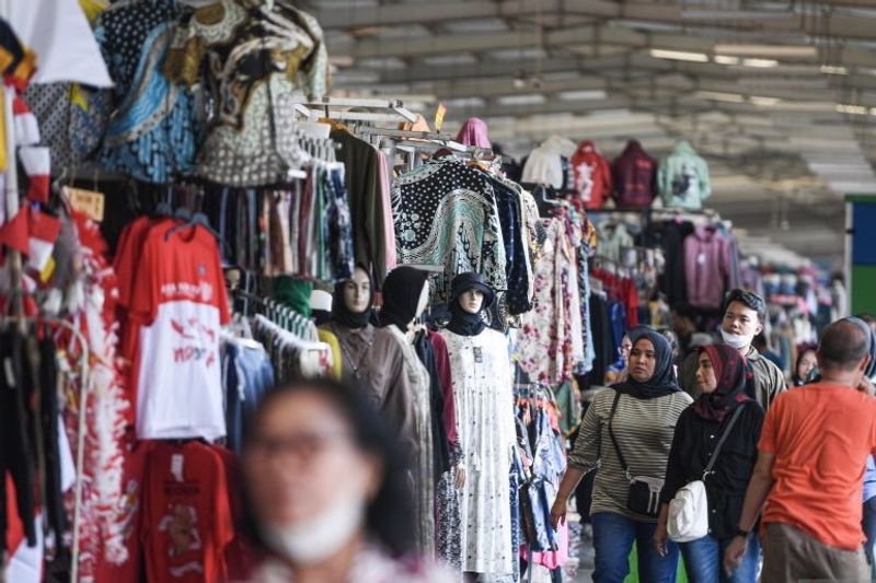 Warga mengamati pakaian yang dijajakan di kawasan Stasiun Tanah Abang, Jakarta,
