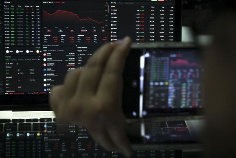 Karyawan mengamati pergerakan Indeks Harga Saham Gabungan (IHSG) menggunakan gawai di Jakarta