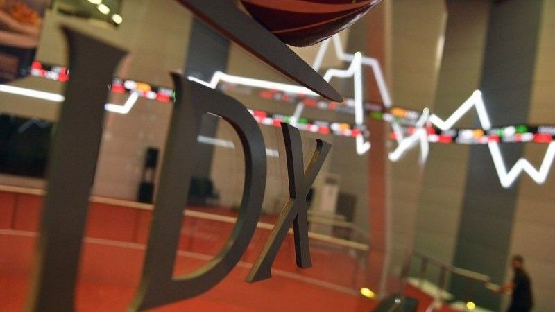 Karyawan melintas di dekat monitor pergerakan Indeks Harga Saham Gabungan (IHSG)