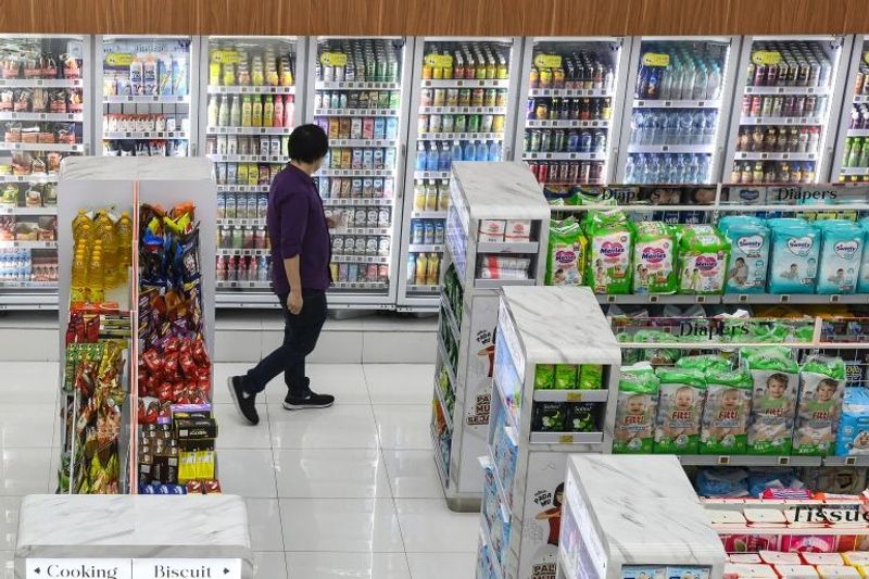 Warga memilih produk minuman yang akan dibeli di toko swalayan