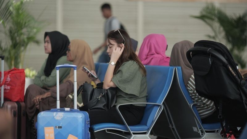 penumpang pesawat sedang menanti keberangkatan di terminal Bandara Internasional Kualanamu