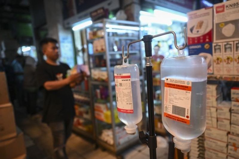 Pekerja melintasi obat-obatan yang dijual di Pasar Pramuka, Jakarta