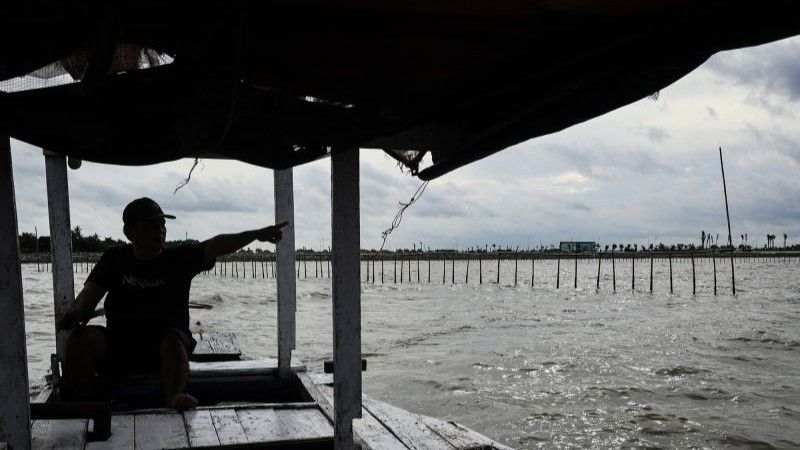 Nelayan menunjukkan pagar laut yang terpasang di kawasan pesisir Kabupaten Tangerang