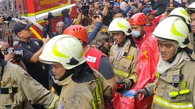 Petugas pemadam kebakaran mengevakuasi jenazah korban kebakaran Glodok Plaza