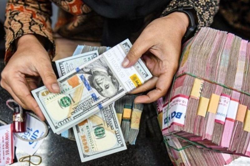 Petugas menyusun uang pecahan dolar AS dan rupiah