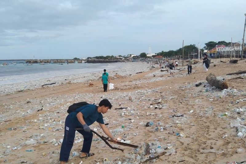 Sukarelawan membersihkan sampah plastik yang terdampar di bibir Pantai Kedonganan