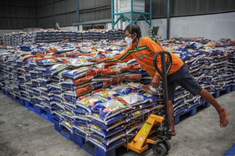 Seorang buruh angkut melakukan bongkar muat beras di Gudang Bulog 
