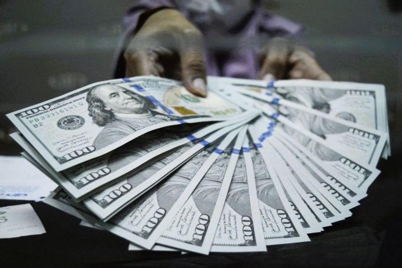 Petugas menunjukkan uang dolar AS