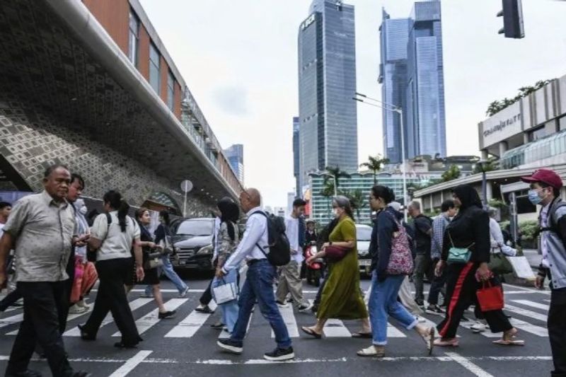 Sejumlah pekerja menyeberangi jalan di kawasan Bundaran HI