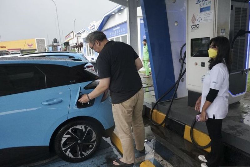 Pemudik melakukan pengisian daya baterai mobil listrik di SPKLU Rest Area Tol Batang-Semarang