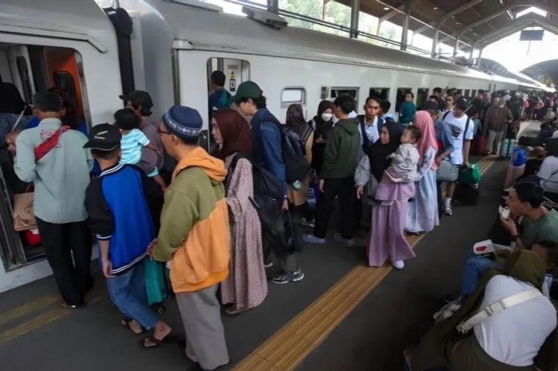 Penumpang memasuki gerbong kereta api di Stasiun Surabaya Gubeng