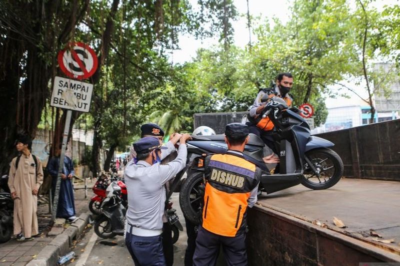 sepeda motor yang parkir di bahu jalan ke atas truk di kawasan Gandaria City, Jakarta