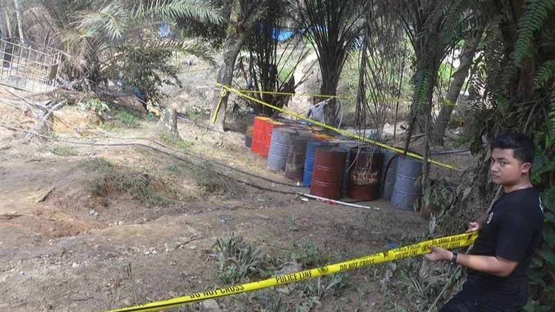 Polisi memasang pita garis pembatas di lokasi sumur minyak tradisional