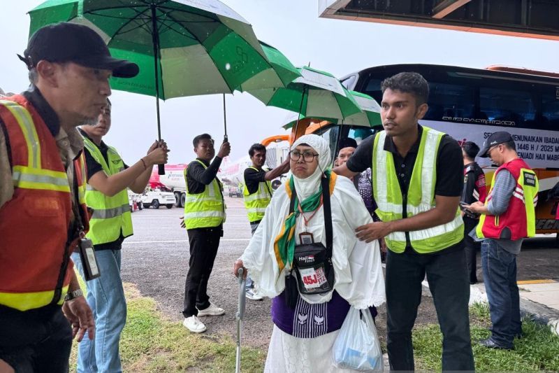 Petugas membantu calon jamaah haji untuk menaiki pesawat di Bandara Internasional Minangkabau