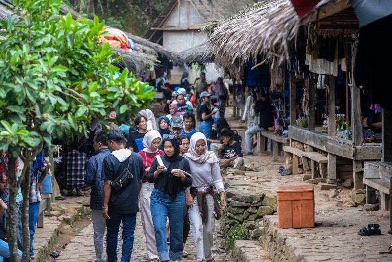 Sejumlah wisatawan berjalan di perkampungan Suku Badui di Desa Kanekes