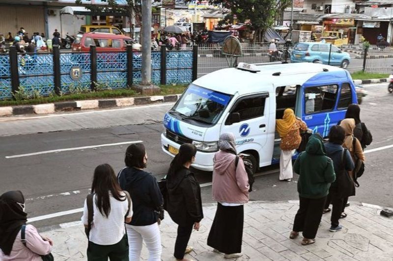 Sejumlah penumpang antre saat akan menaiki JakLingko