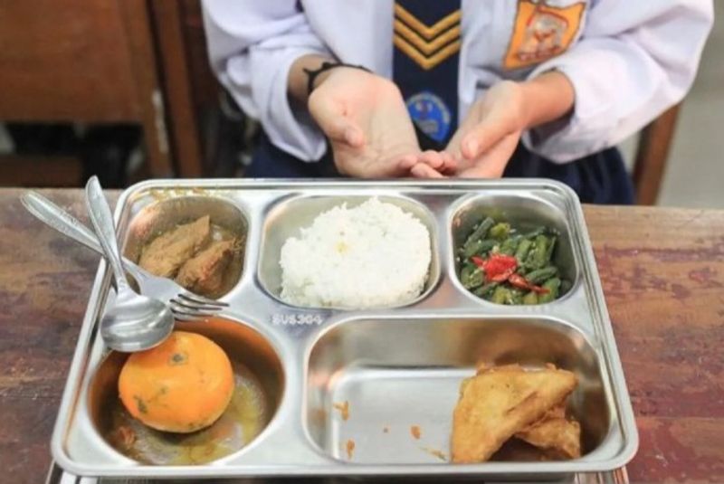 Seorang siswa bersiap menyantap sajian dalam program Makan Bergizi Gratis