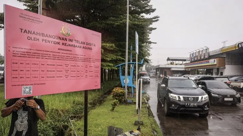 Pekerja memasang plang penyitaan di rest area km 21 B Jalan Tol Jagorawi