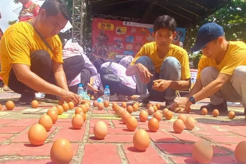 Warga mencoba mendirikan telur di siang hari saat perayaan Peh Cun di Pantai Pasirpadi Pangkalpinang