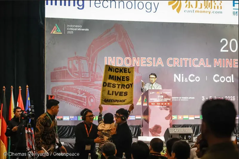 Aktivis Greenpeace Indonesia membentangkan banner bertuliskan “Nickel Mines Destroy Lives” (Tambang Nikel Menghancurkan Kehidupan) saat Wakil Menteri Luar Negeri Arief Havas Oegroseno memberikan sambutan di acara Indonesia Indonesia Critical Minerals Conference 2025 hari ini di Jakarta. (Dhemas Reviyanto/Greenpeace)