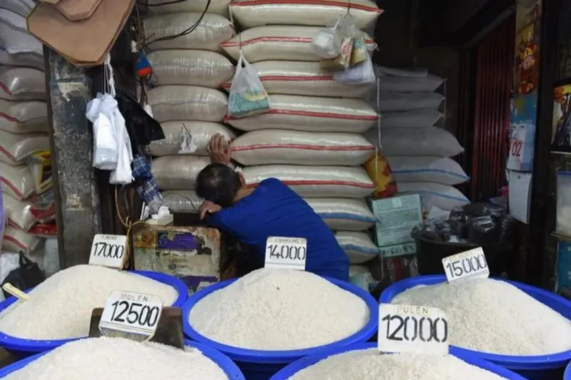 Pedagang tertidur saat menunggu pembeli di kios penjual beras di Pasar Minggu