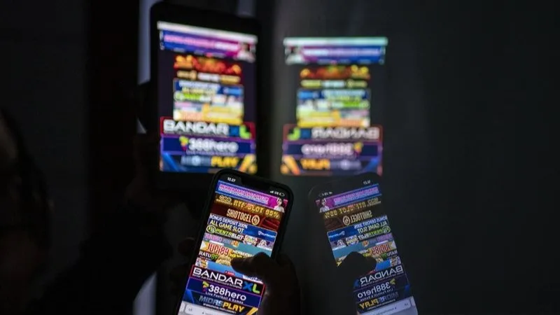 Warga melihat iklan judi online melalui gawainya