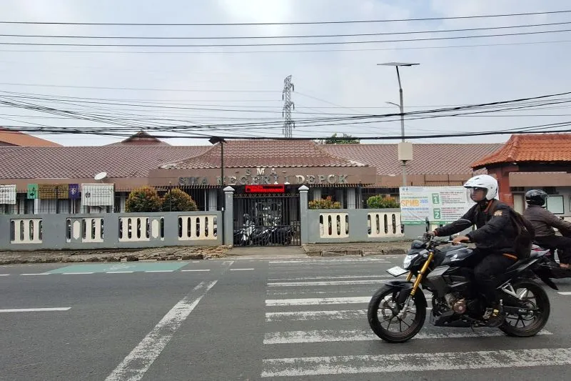 Seorang pngendari sedang melintas di depan gedung SMAN 1 Depok