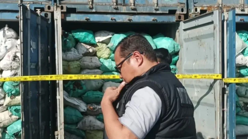 Petugas memasang garis polisi pada sejumlah kontainer berisi batu bara di IKN