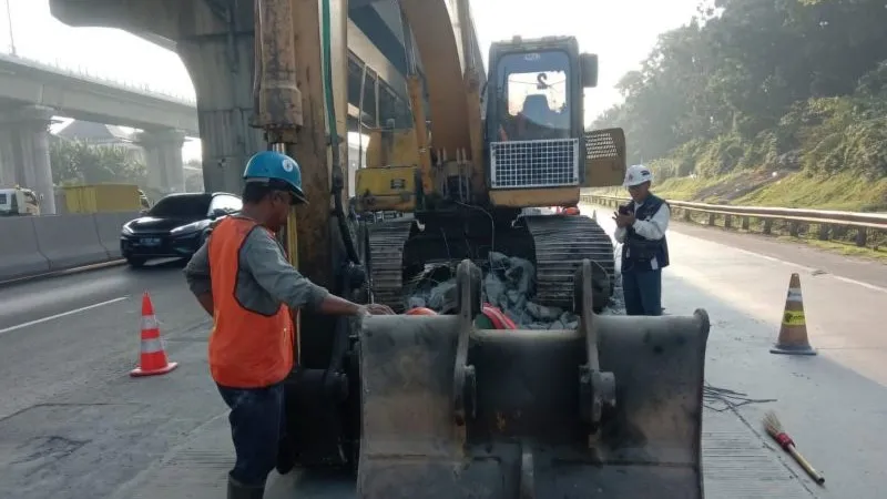 Pekerja PT Jasamarga Trans Jawa memperbaiki jalan rusak di Ruas Tol Jakarta-Cikampek