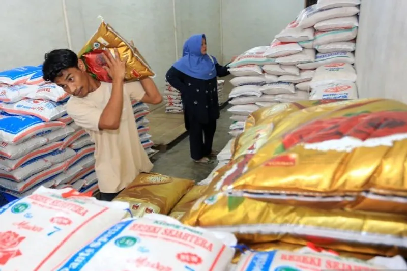 Pekerja membawa karung beras kualitas premium pesanan pelanggannya 