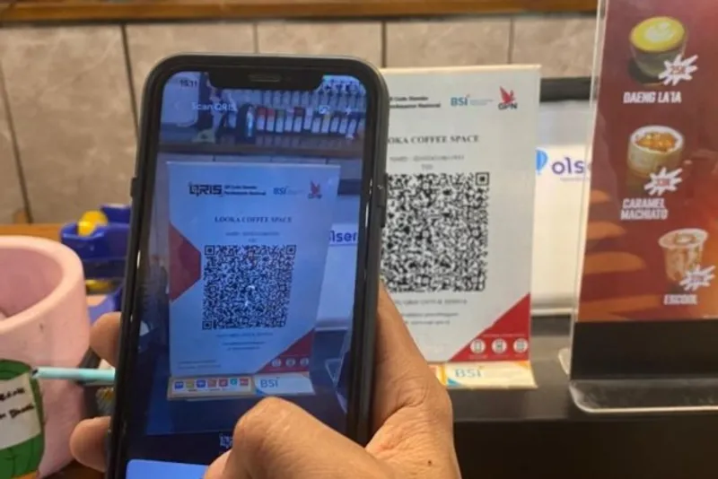 Ilustrasi masyarakat yang membayar dengan QRIS