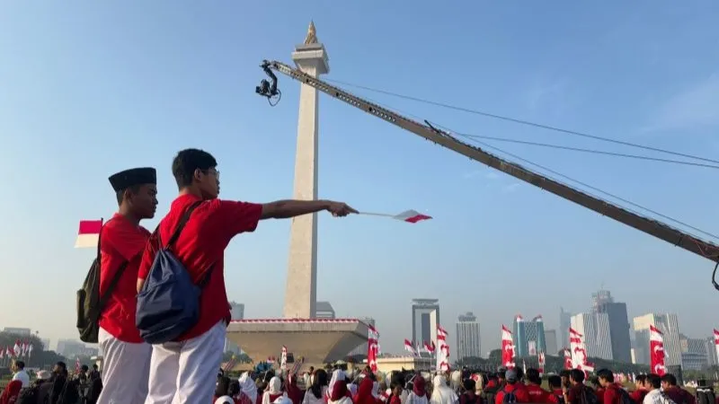 Masyarakat bersiap menyaksikan prosesi kirab bendera Merah Putih di Monas
