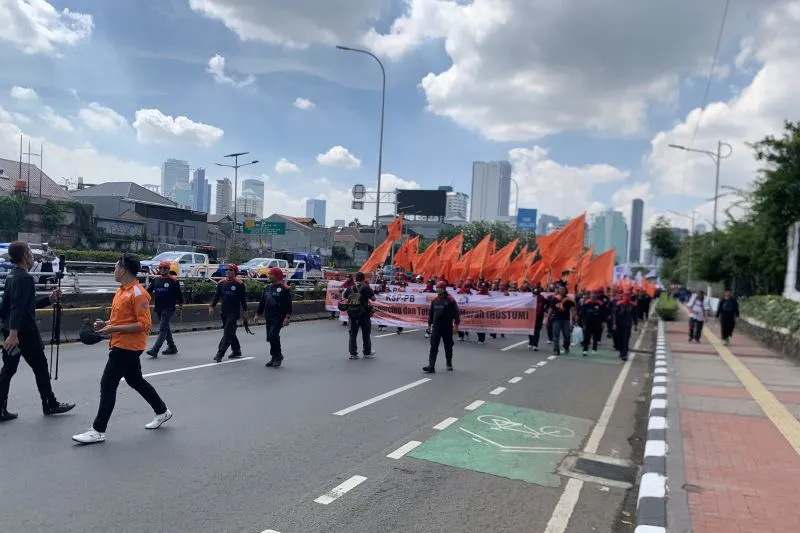 Ribuan buruh berjalan kaki menuju gerbang utama gedung DPR/MPR