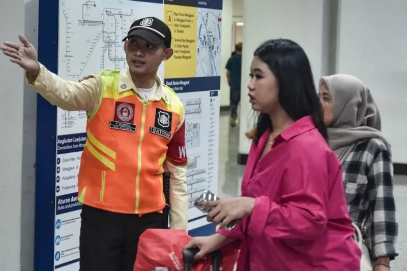 Sejumlah calon penumpang KRL Commuter Line (kanan) menanyakan informasi