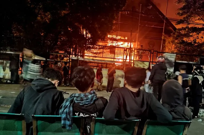 Warga menyaksikan saat detik-detik Kantor DPRD Sulawesi Selatan terbakar di Jalan Urip Sumoharjo