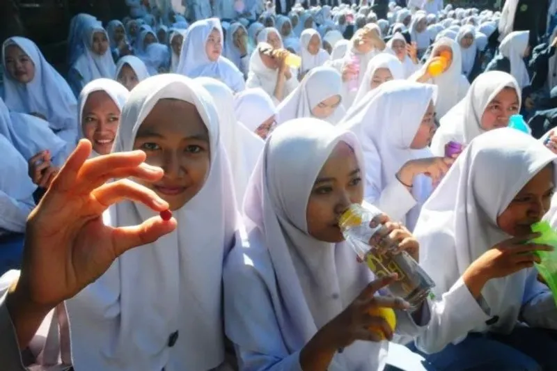 Siswi menunjukkan tablet tambah darah 