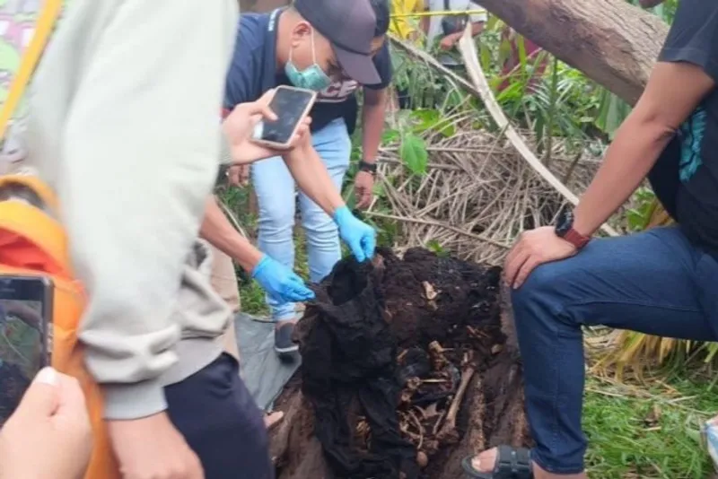 Petugas kepolisian melakukan olah TKP temuan kerangka manusia di dalam pohon aren 