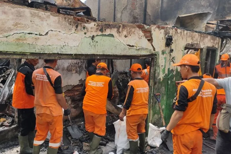 Petugas membersihkan puing kebakaran di Gang Langgar 1, Tangki, Tamansari